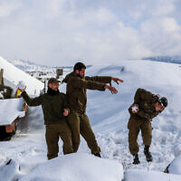 Des soldats israéliens sur le plateau du Golan, recouvert de neige après une tempête qui s'est abattue sur Israël, le 27 janvier 2022. (Crédit : Maor Kinsbursky/Flash90)