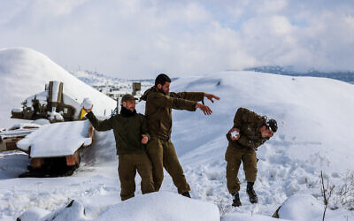 Des soldats israéliens sur le plateau du Golan, recouvert de neige après une tempête qui s'est abattue sur Israël, le 27 janvier 2022. (Crédit : Maor Kinsbursky/Flash90)