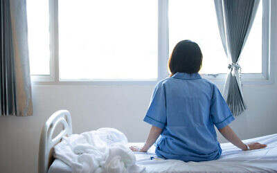 Image d'illustration : femme sur un lit d'hôpital (Crédit : iStock by Getty Images)