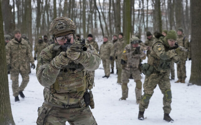 Des membres des Forces de défense territoriale de l'Ukraine, unités militaires volontaires des Forces armées, s'entraînent dans un parc de la ville de Kiev, en Ukraine, le samedi 22 janvier 2022. (Crédit : AP/Efrem Lukatsky)