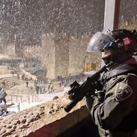 Un agent de la police des frontières monte la garde près de la porte de Damas à Jérusalem-Est, dans la nuit du 27 janvier 2022. (Crédit : Police israélienne)