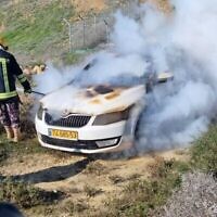 Un pompier éteint les flammes d'une voiture israélienne après qu'elle aurait été incendiée par des extrémistes juifs en Cisjordanie, près de l'avant-poste de Givat Ronen, le vendredi 21 janvier 2022. (Avec l'aimable autorisation de Yesh Din)