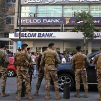 Des membres de l'armée libanaise entourent des manifestants qui se rassemblent devant une banque lors de manifestations continues contre la corruption, le 4 novembre 2019 à Sidon, capitale du sud du Liban. (Mahmoud ZAYYAT / AFP)