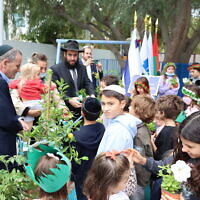 Le rabbin Levi Duchman et le consul général d'Israël à Dubaï Ilan Sztulman et des enfants lors d'un événement de plantation d'arbres à Tou Bichvat aux EAU. (Autorisation)
