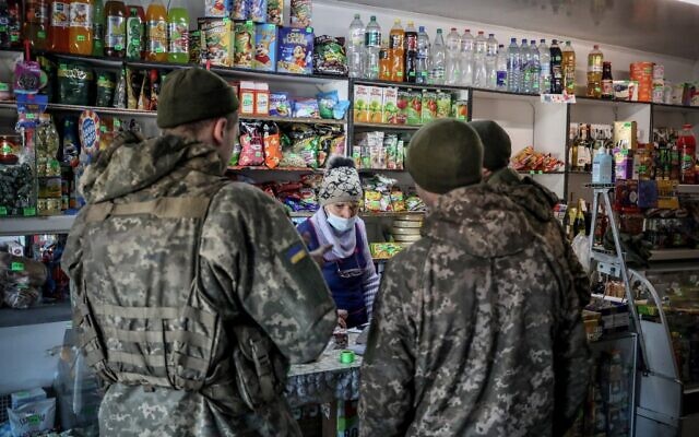 Des militaires des forces armées ukrainiennes font des courses dans la ville d'Avdiivka, dans la région de Donetsk, sur la ligne de front de l'est de l'Ukraine avec les séparatistes soutenus par la Russie, le 21 février 2022. (Crédit : Aleksey Filippov / AFP)