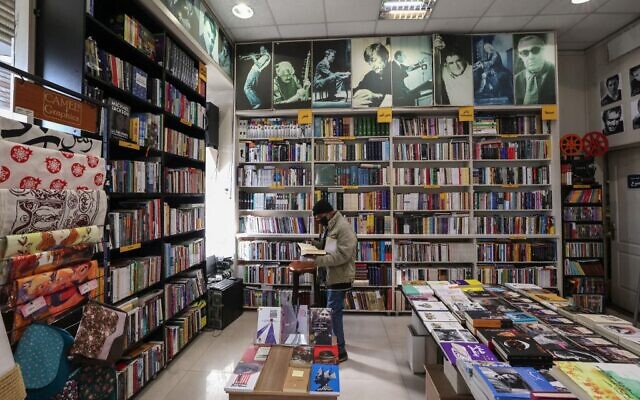 Un Iranien dans une librairie de Téhéran, le 29 janvier 2022. (Crédit : ATTA KENARE / AFP)