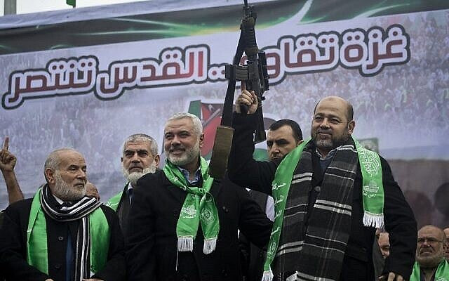 Les dirigeants du Hamas de Gaza Ismail Haniya, au centre, et Mousa Abu Marzouq, à droite, brandissent une arme en saluant des partisans lors d'un défilé marquant le 27e anniversaire de la création du mouvement islamiste le 14 décembre 2014 dans la ville de Gaza. (Crédit: AFP/MAHMUD HAMS)