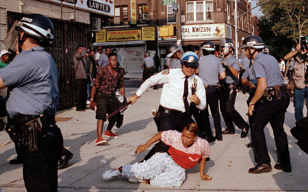 Des agents de la police de la ville de New York se battant avec une manifestante lors d'une manifestation dans le quartier de Crown Heights, dans l'arrondissement de Brooklyn, à New York, le 21 août 1991. Photo d'archives (Crédit : Joe Major/AP Photo)
