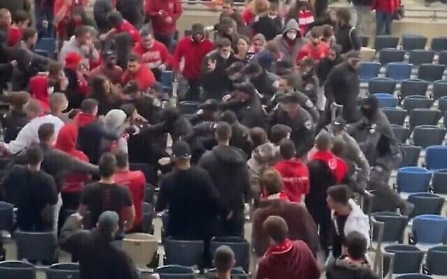 Des policiers se bagarrant avec des supporters de football lors d'un match au stade Sammy Ofer de Haïfa, le 21 février 2022. (Capture d'écran Twitter)