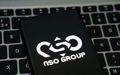 Le logo du NSO Group sur un smartphone placé sur un clavier. (Crédit : Mundissima/Alamy)