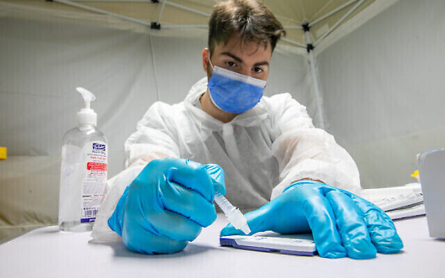 Un soignant en train de procéder à un test de détection antigénique rapide  de la COVID-19 (Yossi Aloni/Flash90)
