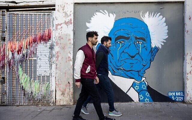 Passant devant un graffiti du regretté David Ben Gourion, premier Premier ministre d'Israël, dans une rue du quartier Neve Tzedek de Tel Aviv. 22 janvier 2022. (Nati Shohat/Flash90)