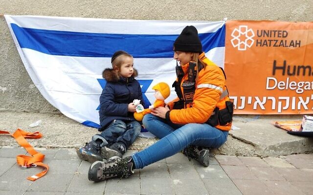Linor Attias, bénévole de United Hatzalah  avec un enfant réfugié d'Ukraine à Kishinev, le 27 février 2022. (Crédit : United Hatzala via Twitter)