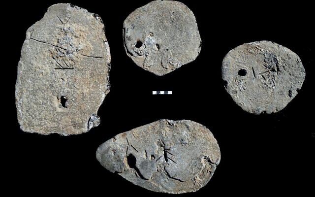 Quatre lingots de plomb datés du 13e au début du 12e siècle avant J.-C., découverts dans la cargaison d'une épave dans le mouillage sud de Césarée, en Israël. (Ehud Galili/Institut d'études maritimes de l'Université de Haïfa)