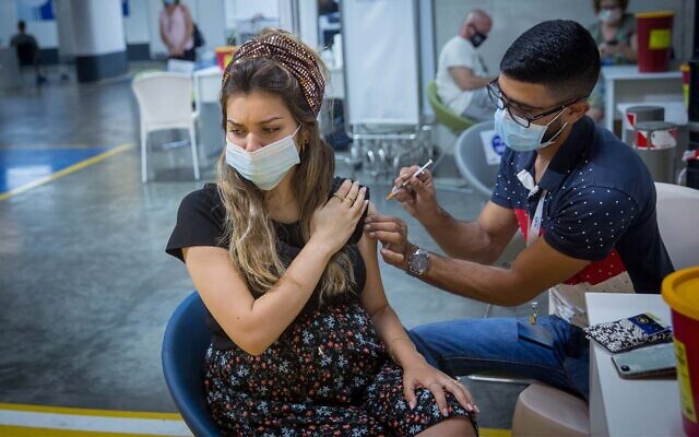 Une femme enceinte se fait vacciner contre la COVID-19 au centre commercial de   Givatayim, aux abords de Tel Aviv, le 23 août 2021. (Crédit : Miriam Alster/Flash90)