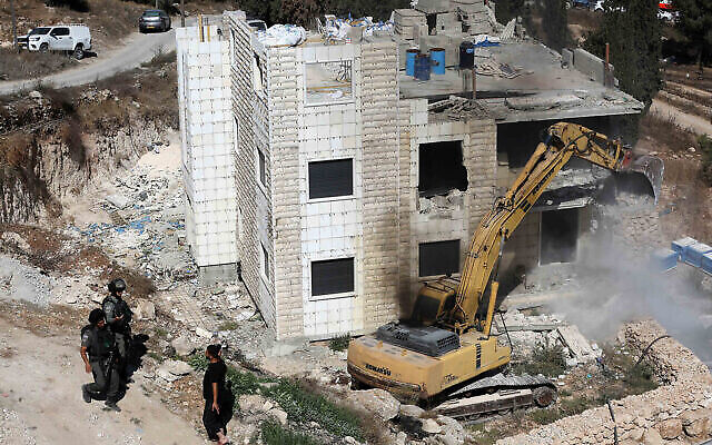 Des troupes israéliennes montent la garde tandis que des bulldozers démolissent une maison dans le village d'Hegrah, en Cisjordanie, dans le sud d' Hébron, le 25 septembre 2019. (Wisam Hashlamoun/Flash90)