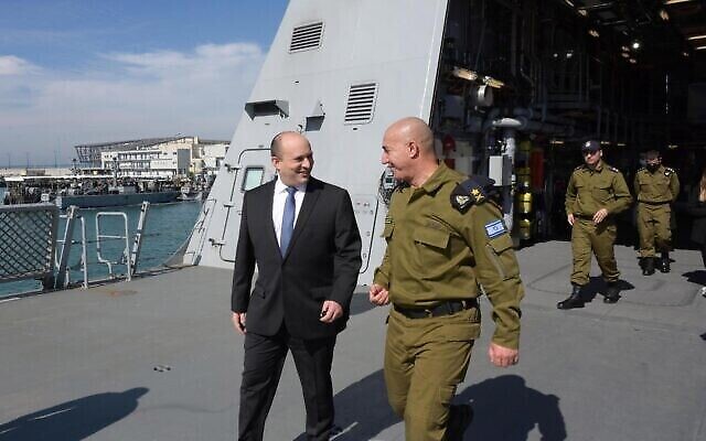 Le Premier ministre Naftali Bennett marche avec le chef de la marine israélienne David Salama lors d'une visite à la base de la marine de Haïfa, le 8 février 2022. (Crédit : Amos Ben-Gershon/Bureau de presse du gouvernement)