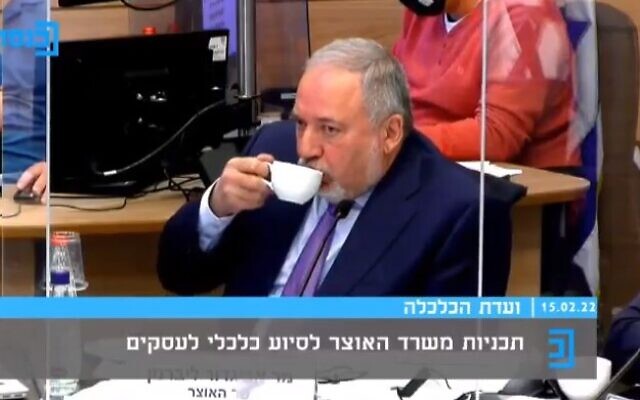 Le ministre des Finances Avigdor Liberman sirotant impassiblement son thé, alors qu'une femme pleure pendant son témoignage devant la commission des Affaires économiques de la Knesset, le 15 février 2022. (Capture d'écran/Knesset TV)