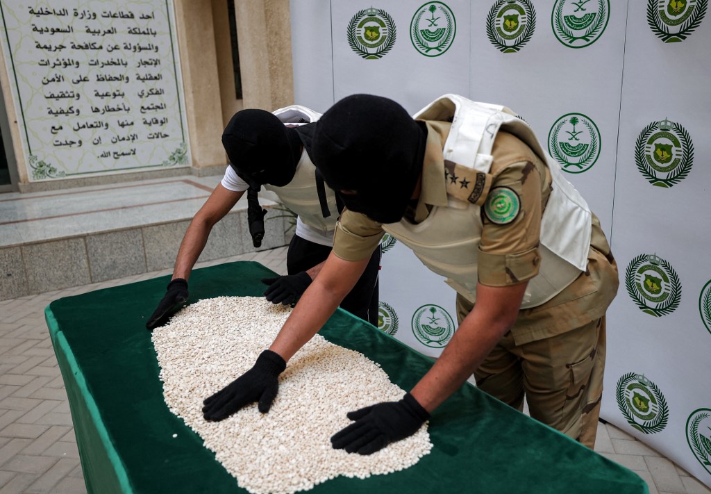 Des agents de la Direction du contrôle des stupéfiants du ministère de l'Intérieur saoudien triant des comprimés de captagon saisis lors d'une opération spéciale et présentés ensuite à l'AFP dans la ville côtière de Jeddah, sur la mer Rouge, le 1er mars 2022. (Crédit : Fayez Nureldine/AFP)