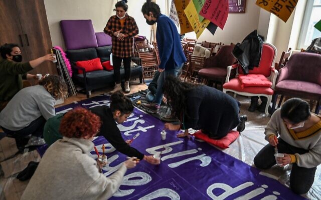 Des militantes peignent des banderoles et des pancartes alors qu'elles se préparent à une marche féministe pour marquer la Journée internationale de la femme dans le quartier de Beyoglu à Istanbul, le 5 mars 2022. (Crédit : Ozan KOSE / AFP)