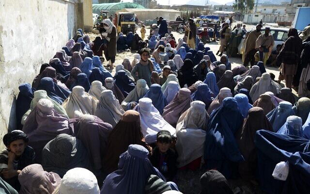 Des femmes attendent dans un bureau du Haut Commissariat des Nations Unies pour les réfugiés (HCR) pour recevoir des articles non alimentaires à Kandahar, le 8 mars 2022. (Crédit :  Javed TANVEER / AFP)