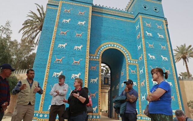 Des touristes étrangers visitent la porte d'Ishtar, la huitième porte de la ville antique de Babylone, à une centaine de kilomètres au sud de la capitale irakienne, Bagdad, le 7 mars 2022. (Crédit : Ahmad AL-RUBAYE / AFP)