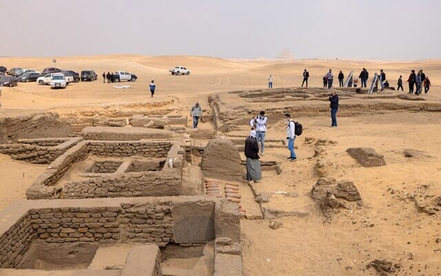 Des journalistes réunis dans la zone où cinq tombes pharaoniques anciennes ont été récemment découvertes sur le site archéologique de Saqqara, au sud de la capitale égyptienne, Le Caire, le 19 mars 2022. (Crédit :  Khaled DESOUKI / AFP)
