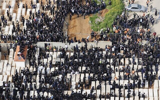 Des juifs ultra-orthodoxes assistent à l'enterrement du rabbin Chaim Kanievsky dans la ville de Bnei Brak, le 20 mars 2022. (Crédit : JACK GUEZ / AFP)