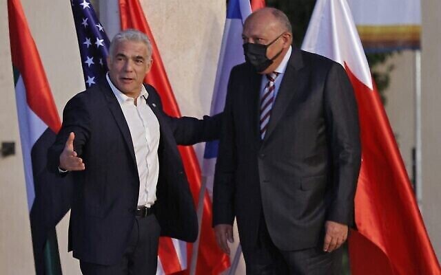 Le ministre israélien des affaires étrangères Yair Lapid, à gauche, salue son homologue égyptien, Sameh Shoukri à son arrivée au Sommet du Neguev, à Sde Boker, le 27 mars 2022. (Crédit : Jack Guez/ AFP)