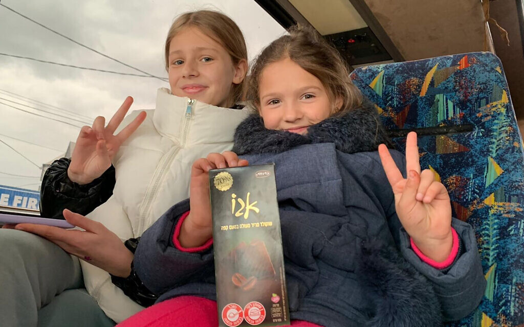 Deux jeunes filles juives ukrainiennes dans un bus organisé pour leurs familles par Christians for Israel en Moldavie, le 7 mars 2022. (Crédit : Christians for Israel/JTA)