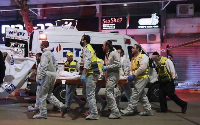 L'équipe israélienne de sauvetage et de récupération Zaka portant le corps d'une victime sur les lieux d'une fusillade à Hadera, le 27 mars 2022. (Crédit : Ariel Schalit / AP Photo)