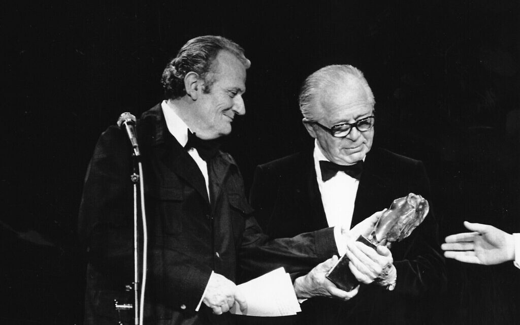 L'écrivain Paul Guimard, représentant spécial du président français François Mitterrand, remettant un trophée au réalisateur américain Billy Wilder (à droite) lors de la cérémonie de la soirée d'ouverture du 35e Festival international du film de Cannes, à Cannes, en France, le 14 mai 1982. (Crédit : AP)