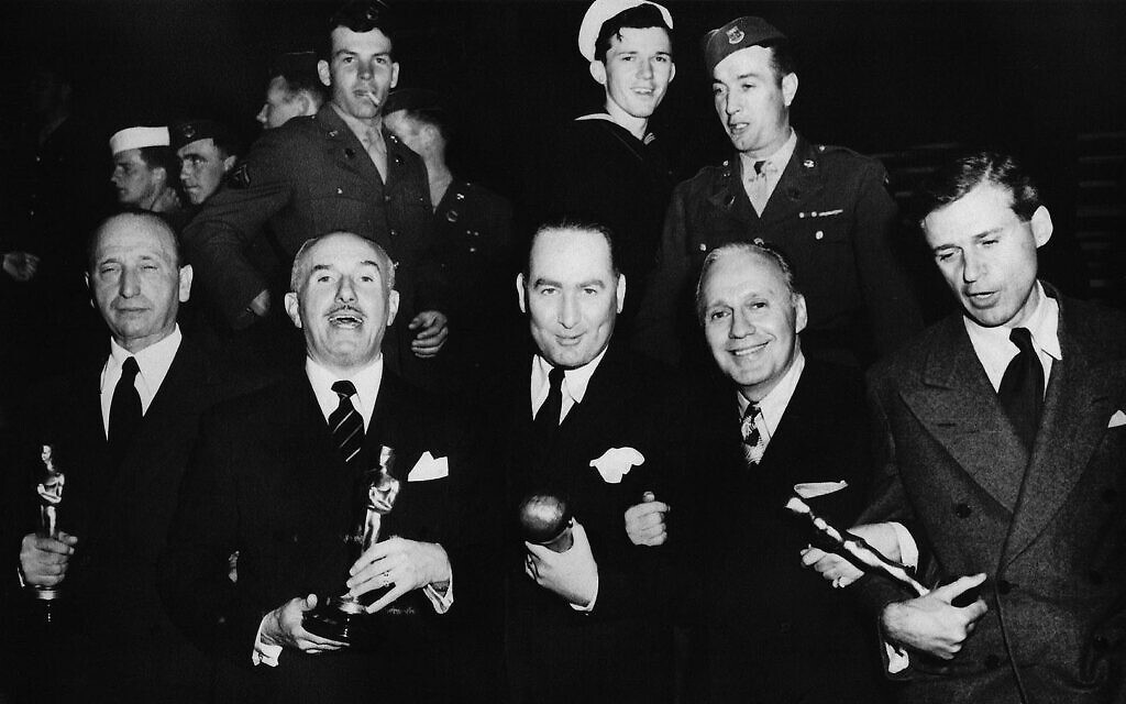 Un quintette de lauréats de "Casablanca" : un Michael Curtiz endormi, Jack Warner (qui parle, comme d'habitude), Hal Wallis (avec son prix Thalberg), l'un des animateurs de l'événement, Jack Benny, et le scénariste Howard Koch. (Crédit : collection de l'auteur)