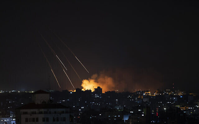Des colonnes de fumée s'élèvent dams le ciel après des frappes de missiles israéliennes sur la ville de Gaza, le 13 mai 2021. (Crédit : AP/Khalil Hamra)