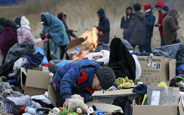 Un enfant choisit des jouets à proximité d'un point de dons de vêtements, alors que les réfugiés fuyant la guerre en Ukraine arrivent au point de passage Medyka à la frontière avec la Pologne, le 28 fevrier 2022. (AP Photo/Visar Kryeziu)