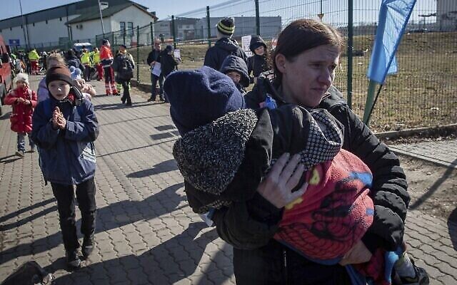 Des réfugiés ukrainiens arrivent à la frontière à Medyka, dans le sud-est de la Pologne, le vendredi 11 mars 2022. Des milliers de personnes ont été tuées et plus de 2,3 millions ont fui le pays depuis que les troupes russes sont entrées en Ukraine le 24 février. (Crédit : AP Photo/Visar Kryeziu)