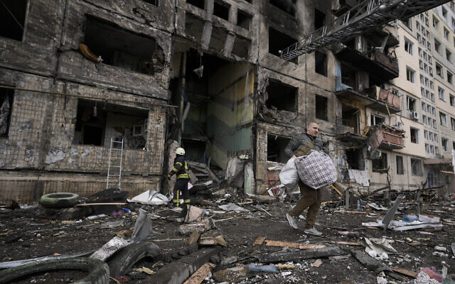 Un résident venu prendre ses effets personnels dans un immeuble frappé par des tirs d'artiellerie à Kiev, en Ukraine, le 14 mars 2022. (Crédit : AP Photo/Vadim Ghirda)