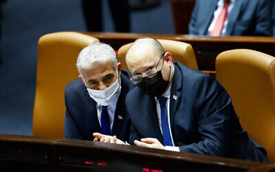 Le Premier ministre Naftali Bennett et le ministre des Affaires étrangères Yair Lapid à gauche, assistent à une session plénière de la Knesset le 31 janvier 2022. (Crédit : Olivier Fitoussi/Flash90)