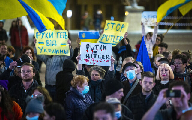Des manifestants brandissent des panneaux et des drapeaux pendant une manifestation contre l'invasion russe de l'Ukraine devant la mairie de Jérusalem, le 28 février 2022. (Crédit :  Olivier Fitoussi/Flash90)