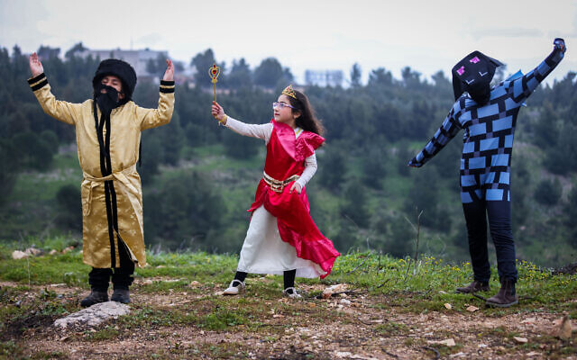 Des enfants en costume posent pour une photo dans la ville israélienne de Tzfat, dans le nord d'Israël, avant la fête de Pourim, le 13 mars 2022. (Crédit :  David Cohen/Flash90)