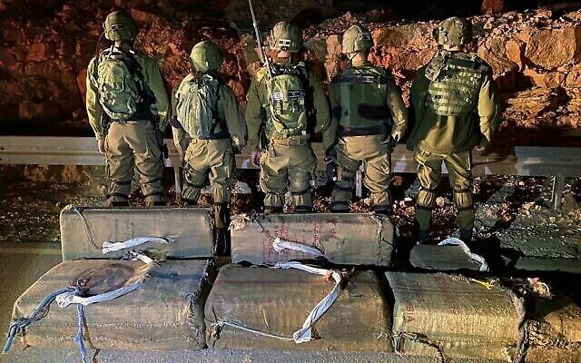 Des soldats posent avec la drogue saisie lors d'une opération de contrebande déjouée à la frontière égyptienne, le 2 mars 2022. (Tsahal)
