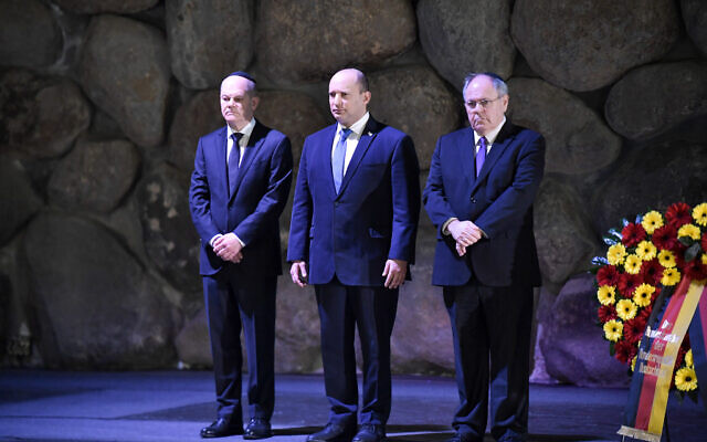 Le chancelier allemand Olaf Scholz (à gauche) visite la salle du mémorial de la Shoah de Yad Vashem, avec le premier ministre Naftali Bennett (à droite) et le président de Yad Vashem Dani Dayan (à gauche), le 2 mars 2022. (Crédit : Kobi Gideon / GPO)