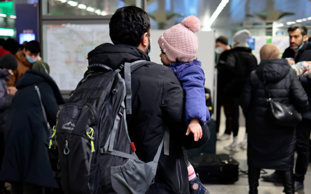 Un homme porte un enfant après l’arrivée de réfugiés ukrainiens à la gare principale de Berlin, le 1er mars 2022. (Hannibal Hanschke/Getty Images via la JTA)