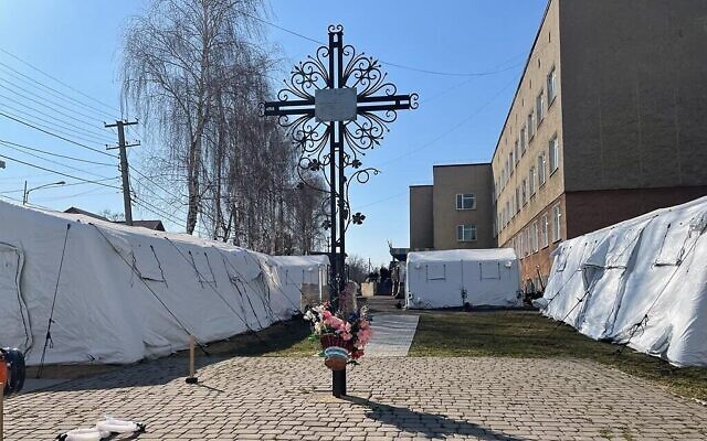 Des travailleurs ukrainiens construisent des tentes pour l'hôpital de campagne israélien en cours de construction à Mostyska, en Ukraine, le 19 mars 2022. (Crédit : Carrie Keller-Lynn/Times of Israel)