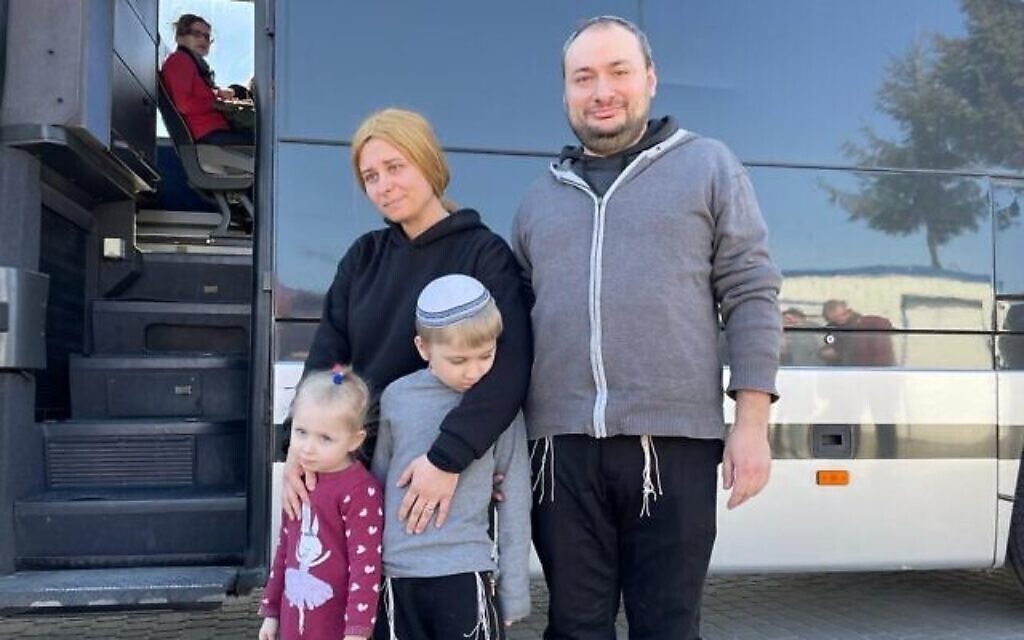 La famille Groisman attend de monter à bord d’un autobus affrété par le ministère des Affaires étrangères près de Krakovets, poste frontalier de l’Ukraine en Pologne, le 23 mars 2022. (Crédit : Carrie Keller-Lynn/The Times of Israel)