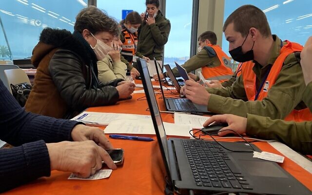 Des soldats du Home Front Command enregistrent les passeports des nouveaux arrivants ukrainiens au terminal 1 de l'aéroport Ben Gourion, le 18 mars 2022. (Crédit : Sue Surkes/ Times of Israel)