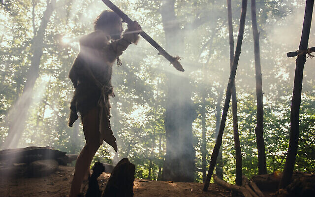 Photo d'illustration : Un homme des cavernes chasse avec une lance. (Crédit : iStock/Getty Images)