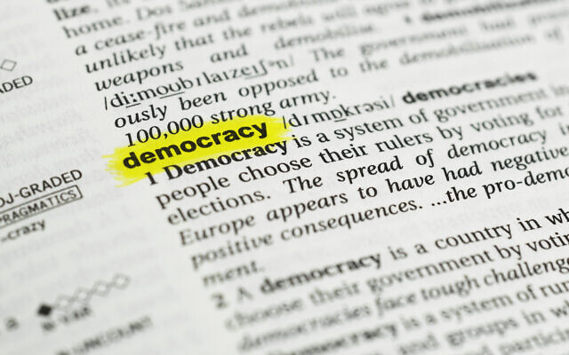 Illustration. Détail du mot anglais "democracy" mis en évidence et sa définition du dictionnaire. (Crédit : iStock)