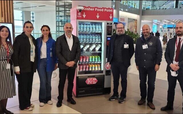 Le rabbin Mendy Chitrick, 3e à droite, à côté du nouveau distributeur de produits alimentaires casher de l'aéroport d'Istanbul. (Crédit : Rabbin  Mendy Chitrik)