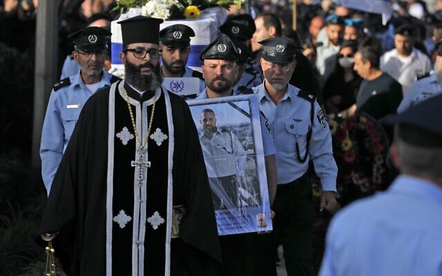 Des policiers israéliens portent le cercueil du policier Amir Khoury, tué lors d'une fusillade terroriste à Bnei Brak, lors de ses funérailles à Nazareth, le 31 mars 2022. (Crédit : JALAA MAREY / AFP)